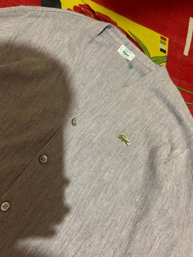VINTAGE IZOD LACOSTE WOOL CARDIGAN (Category: Coats, Jackets and Outerwear) located in Davao. Submitted by thrift_cuttiiee1000 (Listing ID 1461714992, Image 3). Description: Vintage Izod Lacoste acrylic V-neck cardigan in heather grey. Brand: Izod Lacoste — specifically from the era (spanning roughly the 1970s through early 1990s) when American manufacturer Izod held the US licensing rights for France's Lacoste. Tag Era: The white tag with the gr