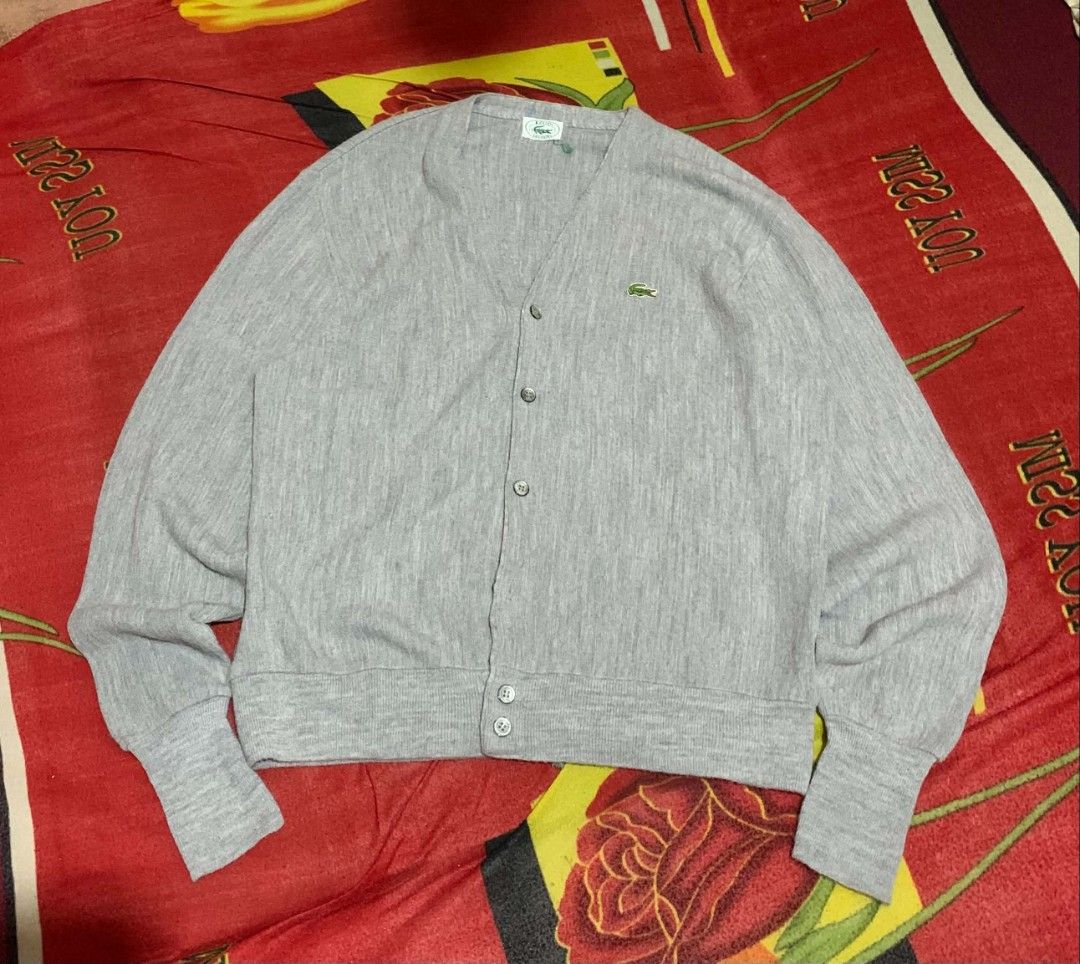 VINTAGE IZOD LACOSTE WOOL CARDIGAN (Category: Coats, Jackets and Outerwear) located in Davao. Submitted by thrift_cuttiiee1000 (Listing ID 1461714992, Image 2). Description: Vintage Izod Lacoste acrylic V-neck cardigan in heather grey. Brand: Izod Lacoste — specifically from the era (spanning roughly the 1970s through early 1990s) when American manufacturer Izod held the US licensing rights for France's Lacoste. Tag Era: The white tag with the gr