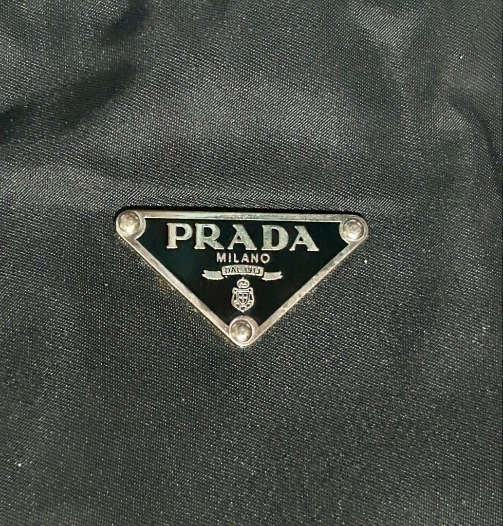 vintage Prada Tessuto nylon tote (Category: Shoulder Bags) located in Plaridel. Submitted by ilovebubu28 (Listing ID 1461793171, Image 3). Description: Pre-owned Prada black Tessuto nylon tote bag featuring dual flat leather top handles, silver tone hardware, triangular Prada logo plaque on front and zip closure top with pull tab. Nylon lined main compartment with single zip pocket..