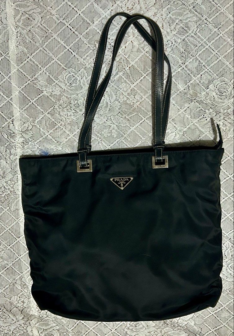 vintage Prada Tessuto nylon tote (Category: Shoulder Bags) located in Plaridel. Submitted by ilovebubu28 (Listing ID 1461793171, Image 2). Description: Pre-owned Prada black Tessuto nylon tote bag featuring dual flat leather top handles, silver tone hardware, triangular Prada logo plaque on front and zip closure top with pull tab. Nylon lined main compartment with single zip pocket..