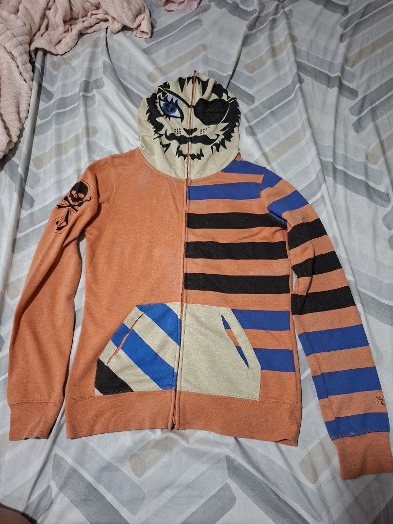Volcom Orange Striped Hoodie (Category: Coats, Jackets and Outerwear) located in Lapu Lapu. Submitted by margaux099 (Listing ID 1461751101, Image 2). Description: - Orange Volcom zip-up hoodie - Size XS - Black and blue stripes on sleeves and hood - Skull and crossbones graphic on left sleeve - Unique tiger face design on the hood - Front pockets.