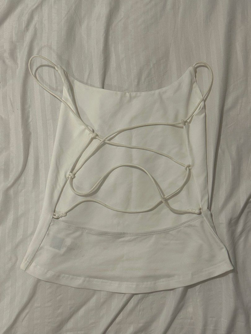 White Backless Cami Tank Top (Category: Sleeveless) located in Santo Tomas. Submitted by prelovedspacesbyji (Listing ID 1461760180, Image 2). Description: - White cami tank top - Features thin spaghetti straps - Cute criss-cross strap detail on the back - Versatile piece for layering or wearing on its own - Easily pairs with jeans or skirts.
