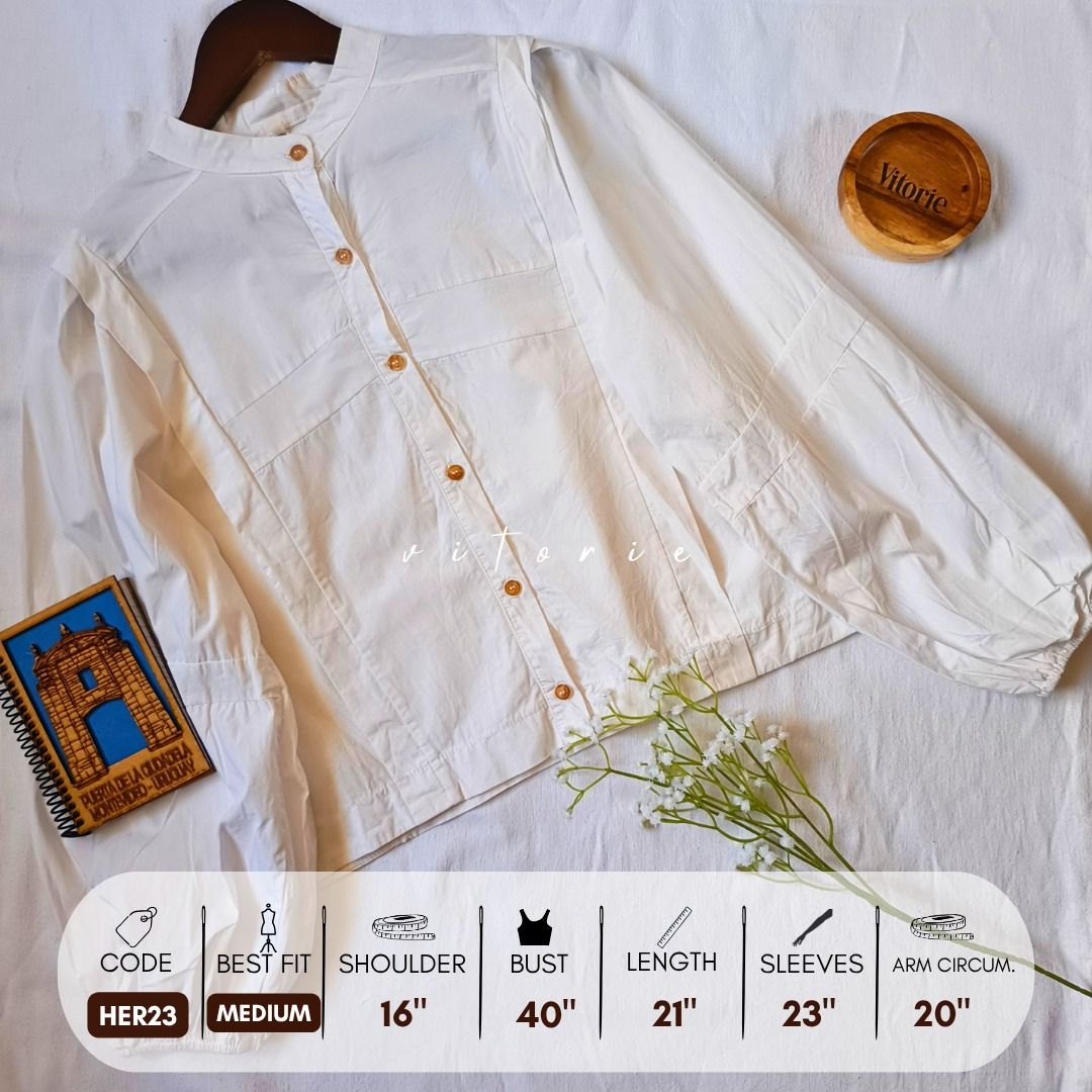 White Mandarin Collar Button-Up Blouse (Category: Blouses) located in Cabuyao City. Submitted by vitorieclothing_lifestyle (Listing ID 1461716216, Image 1). Description: - Elegant white long-sleeved blouse - Mandarin collar - Wooden button-down front - Gathered cuffs - Size: Medium - Bust: 40 inches - Length: 21 inches - Sleeve Length: 23 inches - Arm Circumference: 20 inches.