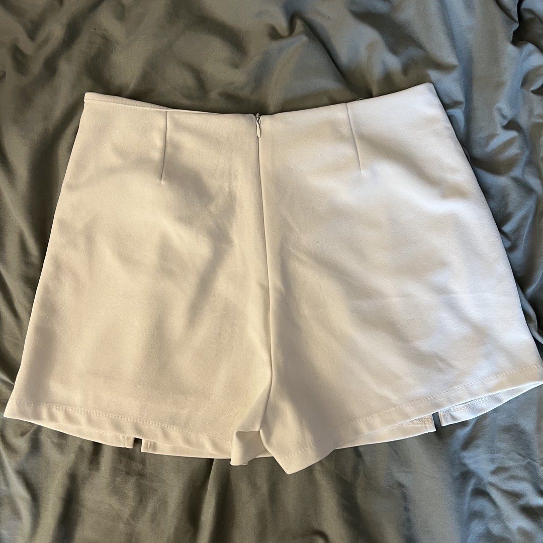 White Skort (Category: Skirts) located in Pasig City. Submitted by cormatzu (Listing ID 1461645702, Image 3). Description: - Stylish white skort - Features front pleats for a flattering look - Convenient back zipper closure - Smooth, slightly stretchy material for comfort - Size L but fits like M - Waist measures approximately 14in or 36cm across - Versatile for casual outings or dressing up.