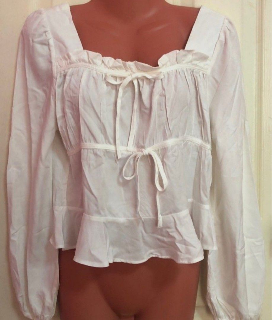 White Square Neck Puff Sleeve Tie Front Peplum Blouse (Category: Blouses) located in Antipolo. Submitted by strawberricae (Listing ID 1461747237, Image 1). Description: - Adorable white blouse - Features a stylish square neckline - Chic puff sleeves - Flattering front tie detail - Flirty peplum hem for added shape - Versatile for dressing up or down - Effortlessly pairs with jeans or skirts.