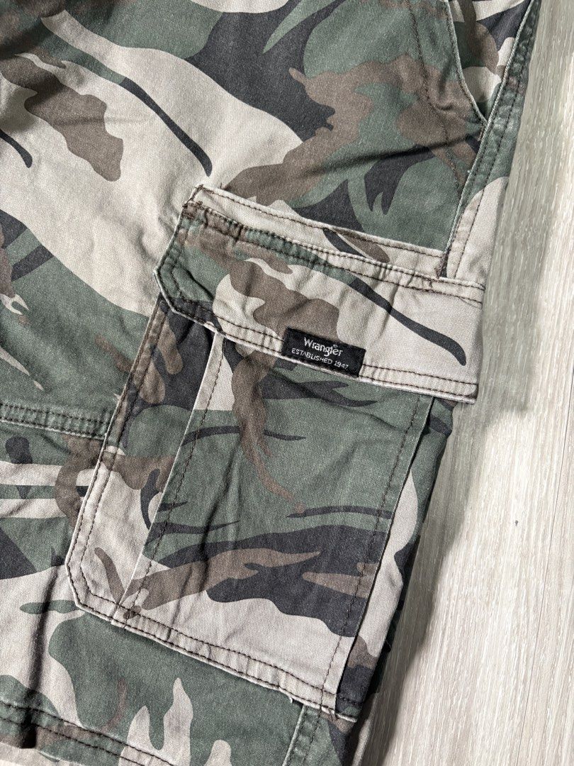 Wrangler Camo Cargo Shorts Size 38 (Category: Shorts) located in Rizal. Submitted by thriftdrip.402 (Listing ID 1461703582, Image 3). Description: - Brand: Wrangler - Type: Camo Cargo Shorts - Size: 38 Waist - Design: Classic camouflage pattern - Features: Multiple pockets for ample storage - Closure: Button and zip fly - Ideal for: Casual wear, outdoor activities - Origin: Made in Bangladesh.