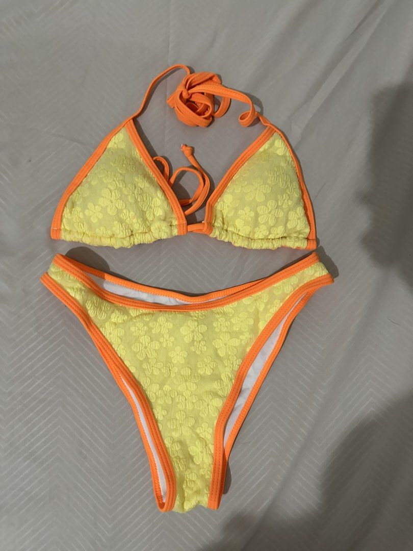 Yellow floral bikini with orange trim (Category: Bikinis & Swimsuits) located in Lipa City. Submitted by chiechums (Listing ID 1461569111, Image 1). Description: - Cute yellow bikini with subtle floral texture - Bright orange trim for a pop of color - Adjustable ties at neck and back - Comfortable cut bottoms - Ideal for beach or pool days.
