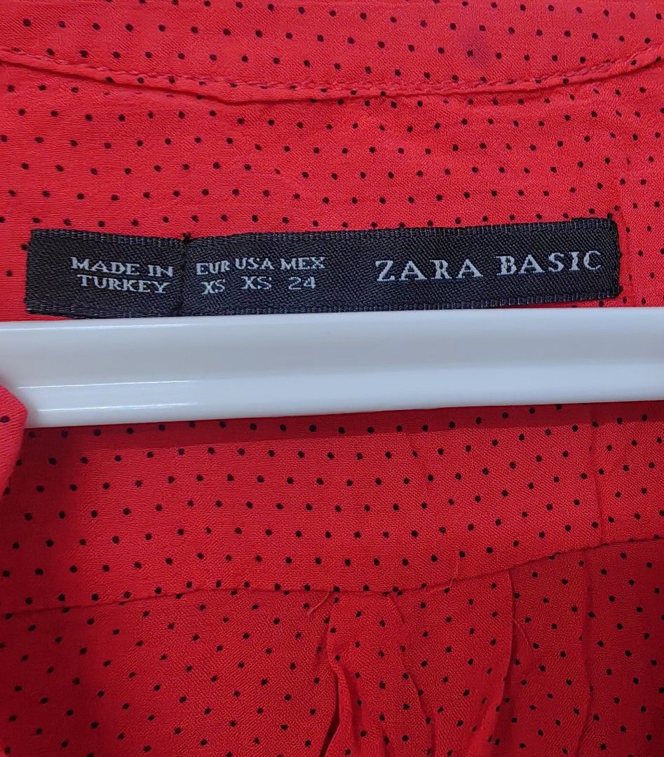 Zara Basic Red Polka Dot Long Sleeve Blouse XS (Category: Blouses) located in Las Pinas. Submitted by offtonewhome (Listing ID 1461566982, Image 3). Description: - Red Zara basic blouse with classic black polka dots. - Features a flattering V-neck with a full button-up front. - Long sleeves with button detail at the cuff. - Convenient small pocket on the left chest. - Please note: a faint dark mark is present on the front, near the pocket (refer 