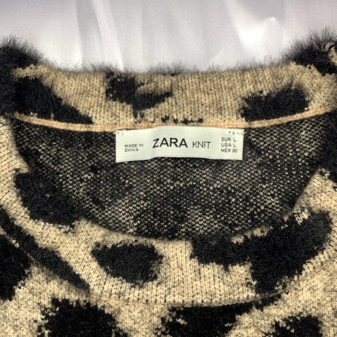 Zara Knit Leopard Print Fuzzy Sweater (Category: Coats, Jackets and Outerwear) located in Rizal. Submitted by shop_ms.lai (Listing ID 1461597885, Image 3). Description: - Zara Knit fuzzy sweater - Classic leopard print design - Long sleeves and crew neck - Black ribbed knit hem and cuffs - Material: Nylon, Viscose, Polyester blend - Comfortable and stylish for casual outfits - Size: Large (L).