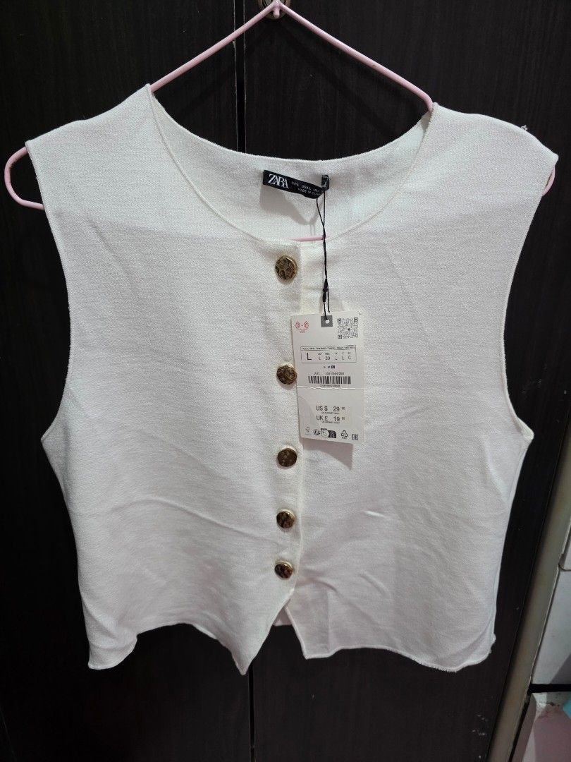 ZARA White Sleeveless Collared Button-Up Top Size L (Category: Sleeveless) located in Caloocan City. Submitted by anjgeroni70315 (Listing ID 1461679530, Image 3). Description: - Brand: ZARA - Type: Sleeveless Top - Color: White - Size: L - Neckline: Collared - Details: Gold buttons down the front - Condition: Brand new with original tags attached.