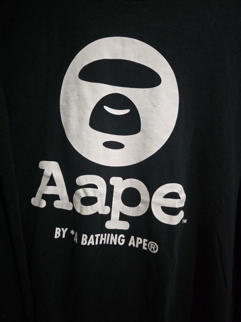 A Bathing Ape Aape Long Sleeve Tee Black (Category: Tshirts & Polo Shirts ) located in Quezon City. Submitted by kick_mnl (Listing ID 1461865983, Image 2). Description: - Brand: A Bathing Ape (BAPE) - Item: Long Sleeve T-Shirt - Color: Black - Features: Iconic ape head logo on front - Detail: Small red camouflage patch on sleeve - Style: Casual wear.