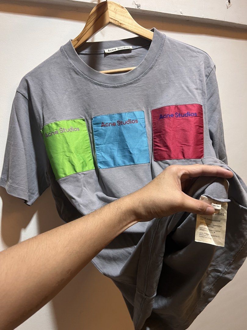 Acne Studios Grey T-shirt with Colour Block Pockets (Category: Tshirts & Polo Shirts ) located in San Juan, La Union. Submitted by jeggystyle (Listing ID 1461963344, Image 2). Description: - Grey Acne Studios t-shirt - Features three small, colorful pockets on the front (green, blue, red) - Short sleeves and crew neck design - Simple, stylish, and ideal for casual wear Fits large.