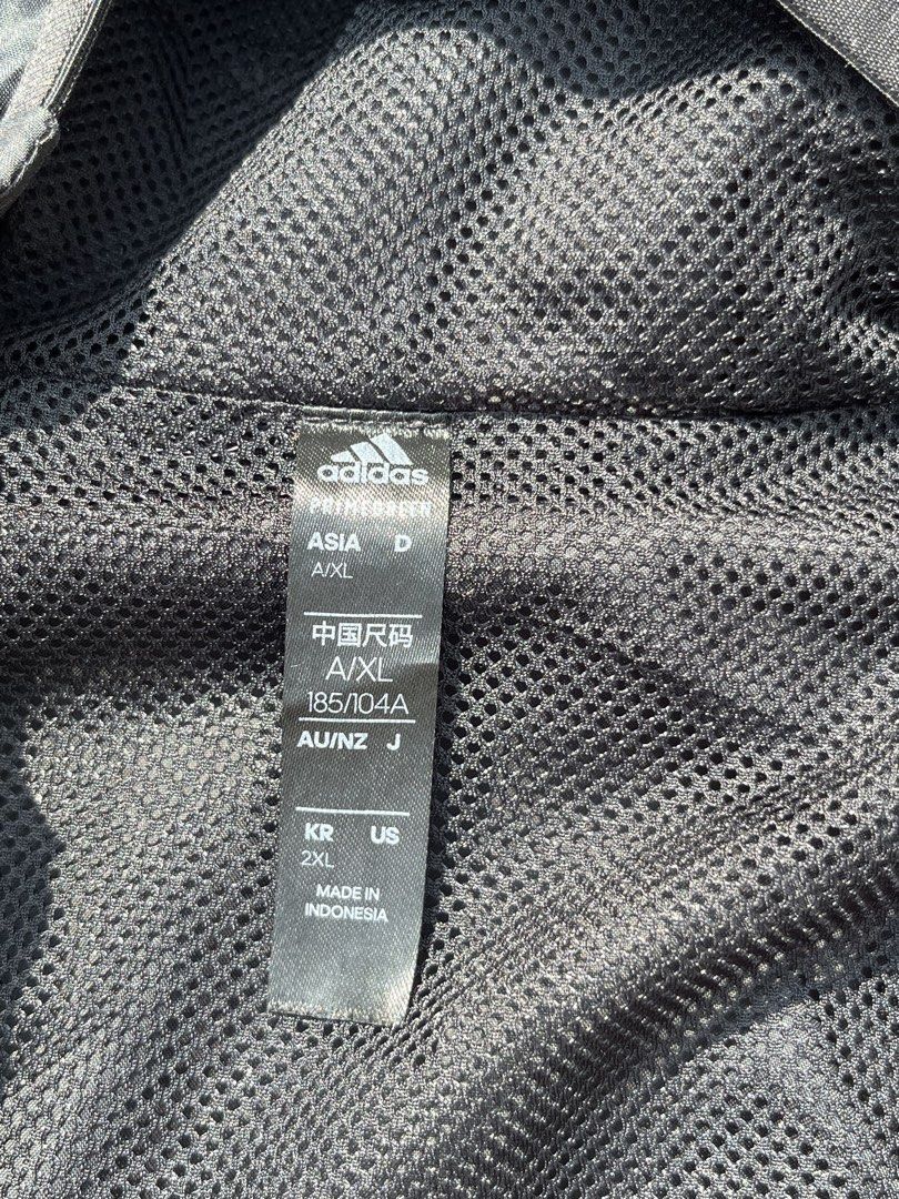 Adidas Black Windbreaker Jacket with White Stripes (Category: Coats, Jackets and Outerwear) located in Davao. Submitted by notoriousthrift (Listing ID 1461857189, Image 3). Description: - Classic black Adidas windbreaker jacket - Iconic three white stripes on sleeves - Features a hood - Zippered pockets for secure storage - Made in Indonesia - Size: 2XL -Dimes 23x29 - Ideal for casual wear or sports activities.