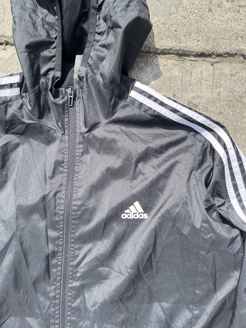 Adidas Black Windbreaker Jacket with White Stripes (Category: Coats, Jackets and Outerwear) located in Davao. Submitted by notoriousthrift (Listing ID 1461857189, Image 2). Description: - Classic black Adidas windbreaker jacket - Iconic three white stripes on sleeves - Features a hood - Zippered pockets for secure storage - Made in Indonesia - Size: 2XL -Dimes 23x29 - Ideal for casual wear or sports activities.