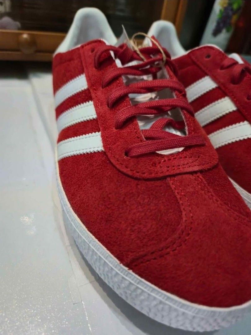 Adidas Gazelle Red Suede Sneakers (Category: Sneakers) located in Manila. Submitted by hello.chinggu (Listing ID 1461908850, Image 2). Description: - Classic Adidas Gazelle sneakers - Vibrant red suede material - Iconic three stripes design - Gold 'Gazelle' lettering detail - White sole and laces - Features OrthoLite sockliner for enhanced comfort - Ideal for casual wear and everyday styling used only once as it is the wrong size for me.