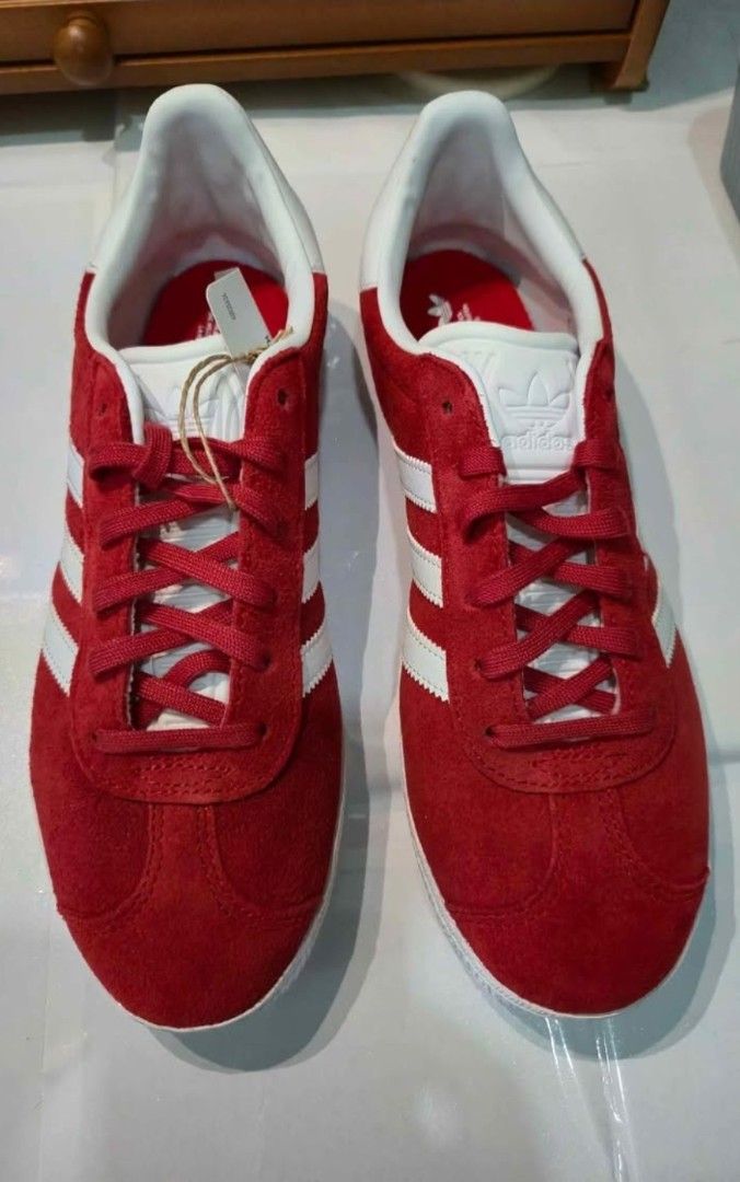 Adidas Gazelle Red Suede Sneakers (Category: Sneakers) located in Manila. Submitted by hello.chinggu (Listing ID 1461908850, Image 1). Description: - Classic Adidas Gazelle sneakers - Vibrant red suede material - Iconic three stripes design - Gold 'Gazelle' lettering detail - White sole and laces - Features OrthoLite sockliner for enhanced comfort - Ideal for casual wear and everyday styling used only once as it is the wrong size for me.