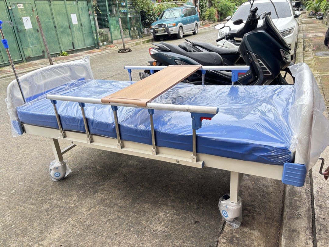 Adjustable Hospital Bed with Wheels and Tray (Category: Medical Supplies & Tools) located in Manila. Submitted by rosel2001 (Listing ID 1461833512, Image 2). Description: - Adjustable hospital bed - Includes side tray - Equipped with wheels for easy mobility - Safety side rails for added security - IV pole attachment point - Mattress covered in blue plastic - Ready for immediate use.