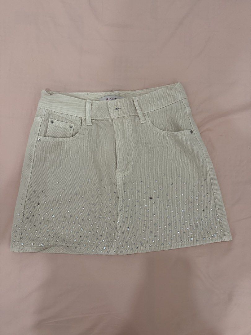 AIMEE Embellished Denim Mini Skirt (Category: Skirts) located in Tuguegarao City. Submitted by joysmithznjo (Listing ID 1461941692, Image 1). Description: - Cream denim mini skirt from AIMEE - Features all-over rhinestone embellishments on the hem - Classic five-pocket design - Zipper and button closure - Size: 160/68A (Medium) - Made in China - Perfect for versatile styling, dress up or down.