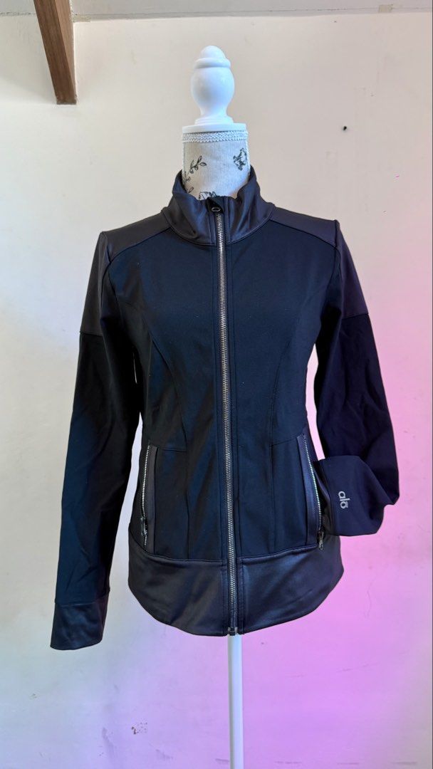 Alo Yoga Contour Jacket (Category: Coats, Jackets and Outerwear) located in Quezon City. Submitted by prelovedstuffshop (Listing ID 1461826534, Image 1). Description: High stand collar * Full front zipper * Two front zip pockets * Fitted/contoured construction * Black 87% nylon / 13% spandex fabric.