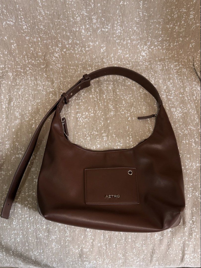 AZTRID Crossbody Bag Medium - Dark Brown (Category: Shoulder Bags) located in Taguig. Submitted by mandms09 (Listing ID 1461893684, Image 1). Description: - Brand: AZTRID - Color: Brown - Material: Faux Leather - Compartments: Zippered main compartment, front pocket with snap closure - Strap: Adjustable - Style: Simple and classic - Ideal for: Everyday use.