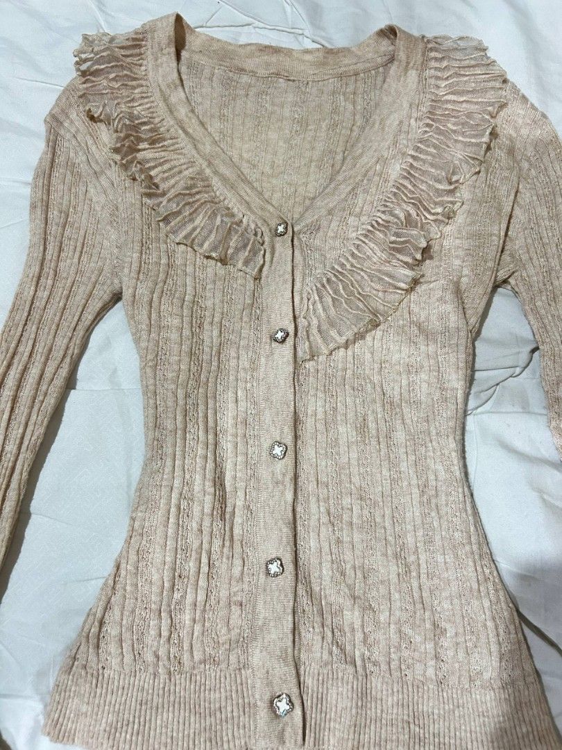 Beige Ruffled V-Neck Button-Up Cardigan (Category: Coats, Jackets and Outerwear) located in Caloocan City. Submitted by geliethrift_26 (Listing ID 1461804605, Image 2). Description: fits small to med since it's stretchable fabric is NOT itchyyyyy, promise no issue snatched for design purposes only.