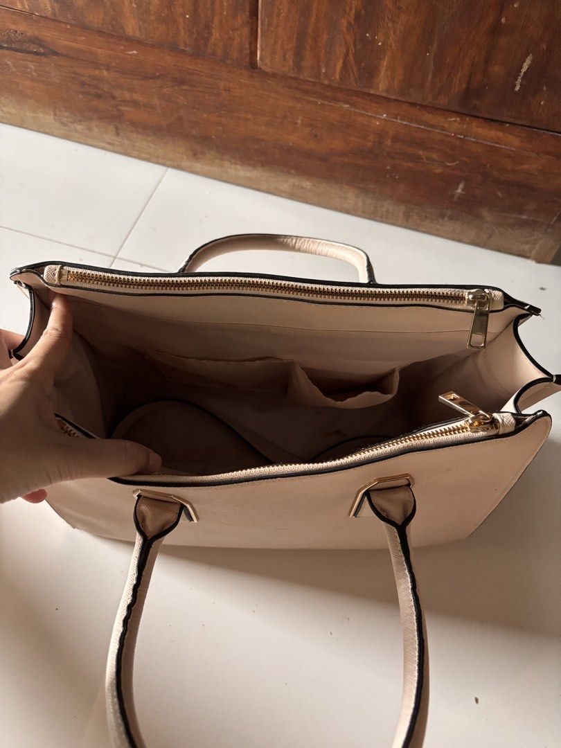 Beige Structured Handbag with Gold Hardware (Category: Luxury Bags & Wallets) located in Baliuag. Submitted by stealthetrends (Listing ID 1461837441, Image 2). Description: - Structured beige handbag - Secure zip closure on top - Interior pockets for easy organization - Elegant gold hardware details on front and handles - Clean interior - Ideal for everyday use or professional settings.