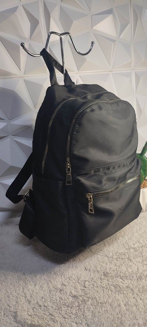 Black Nylon Backpack with Gold Zippers (Category: Backpacks) located in Pasig City. Submitted by xcess_baggage (Listing ID 1461889611, Image 2). Description: - Classic black backpack - Durable nylon material - Multiple zippered compartments for organization - Stylish gold-tone zippers - Adjustable shoulder straps for comfort - Ideal for daily use or travel.