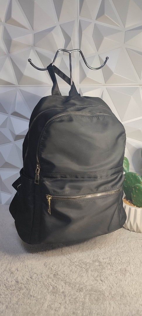 Black Nylon Backpack with Gold Zippers (Category: Backpacks) located in Pasig City. Submitted by xcess_baggage (Listing ID 1461889611, Image 1). Description: - Classic black backpack - Durable nylon material - Multiple zippered compartments for organization - Stylish gold-tone zippers - Adjustable shoulder straps for comfort - Ideal for daily use or travel.