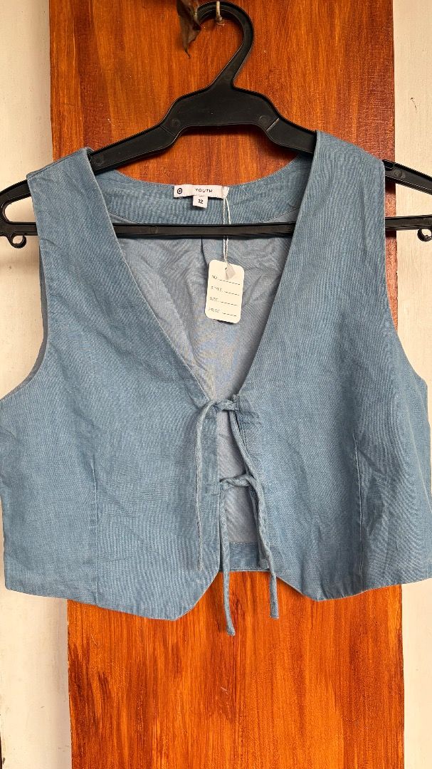 Blue Denim Tie-Front Crop Vest (Category: Sleeveless) located in Daraga. Submitted by hannah.clo (Listing ID 1461853501, Image 1). Description: - Cute blue denim vest - Cropped length - Tie-front closure - Sleeveless design - Size 12 - Great for layering over tops or dresses - Adds a casual vibe.
