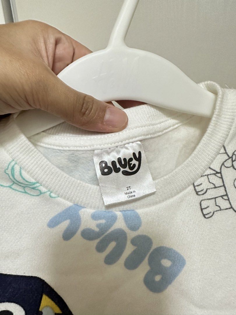 Bluey Kids' Sweater Size 2T (Category: Babies & Kids Fashion) located in Valenzuela. Submitted by shopwithmika (Listing ID 1461954753, Image 2). Description: - White long-sleeved sweater for kids - Features an all-over Bluey character print - 'Bluey' text printed in blue - Made in China - Ideal for young Bluey fans.