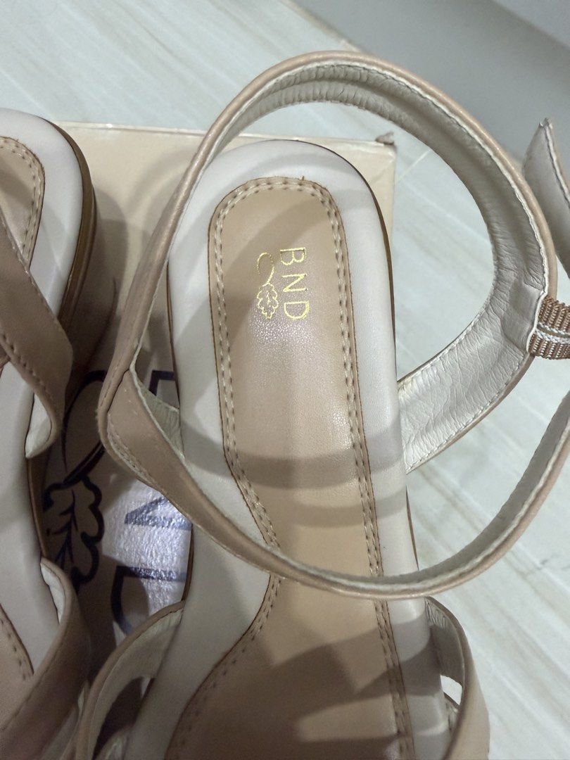 BND Beige Wedge Sandals with Ankle Strap (Category: Sandals) located in Lipa City. Submitted by michellesclosetph (Listing ID 1461912669, Image 3). Description: - Brand: BND - Color: Beige - Style: Wedge Sandals - Features: Criss-cross strap design, adjustable ankle strap with buckle closure - Heel Type: Comfortable wedge - Includes: Original box - Versatility: Perfect for dressing up or down - Sign of use in the straps - Bought for 1400.
