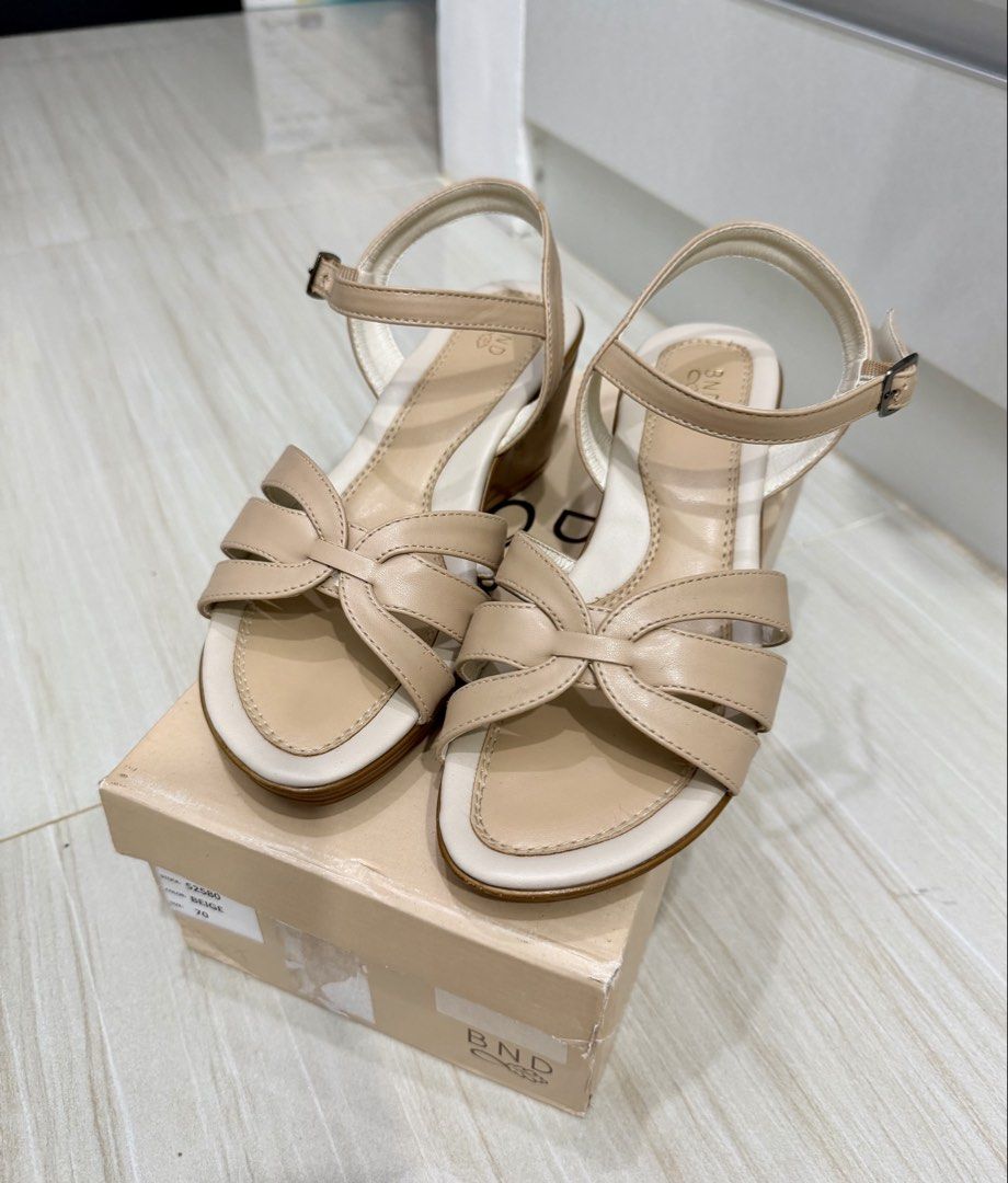 BND Beige Wedge Sandals with Ankle Strap (Category: Sandals) located in Lipa City. Submitted by michellesclosetph (Listing ID 1461912669, Image 2). Description: - Brand: BND - Color: Beige - Style: Wedge Sandals - Features: Criss-cross strap design, adjustable ankle strap with buckle closure - Heel Type: Comfortable wedge - Includes: Original box - Versatility: Perfect for dressing up or down - Sign of use in the straps - Bought for 1400.