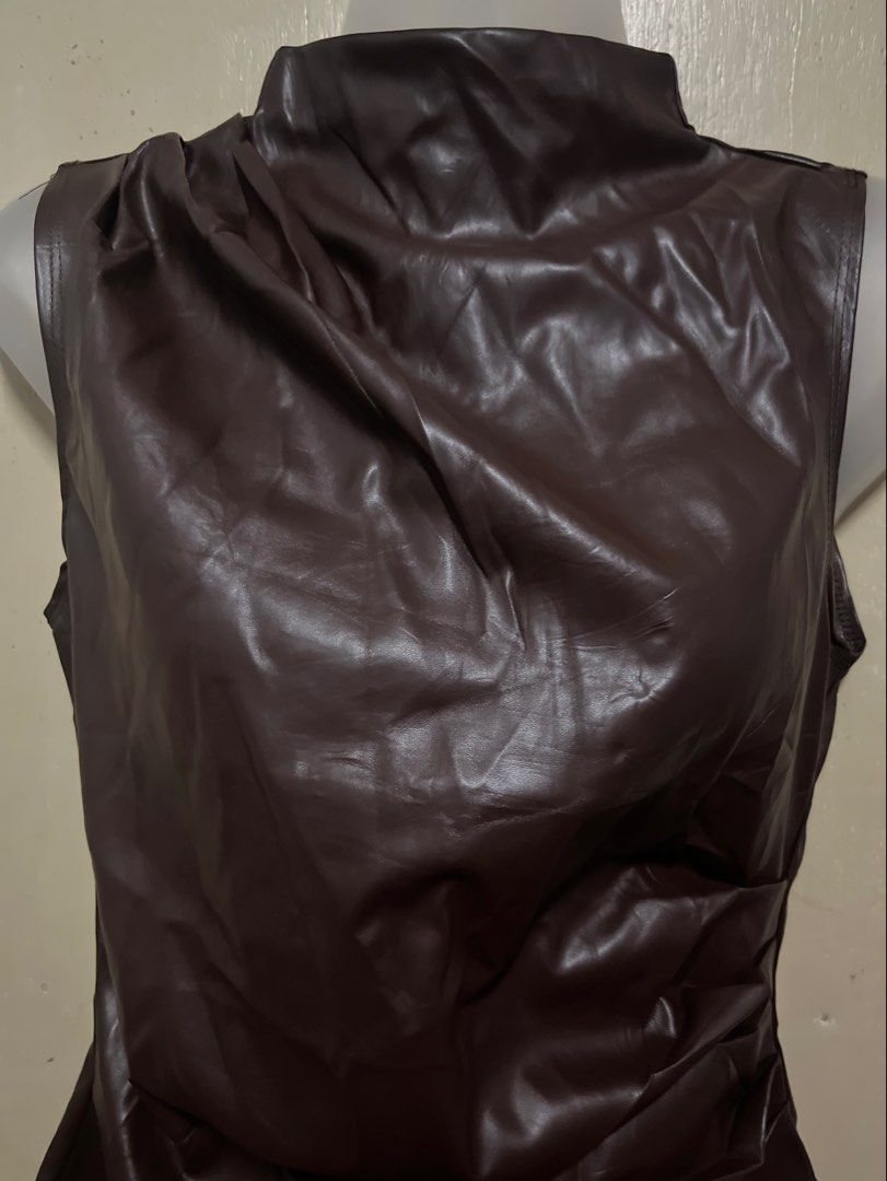 Brown Faux Leather Sleeveless Mock Neck Top (Category: Sleeveless) located in Tabuk. Submitted by zenwolf-1867 (Listing ID 1461947634, Image 3). Description: - xs on tag but can fit up to small -Sleeveless top with a chic mock neck - Made from luxurious deep brown faux leather - Elegant ruched detail at the neckline - Flattering peplum hem - Perfect for pairing with skirts or trousers - Unique and stylish design.