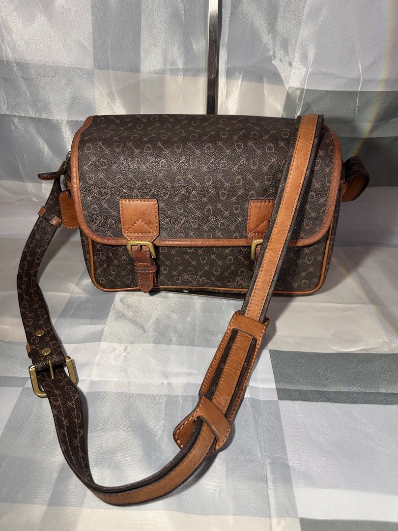Brown Monogram Crossbody Bag with Leather Trim (Category: Cross-body Bags) located in Cavite. Submitted by bags_unltd143 (Listing ID 1461839389, Image 3). Description: Brown crossbody bag with a repeating monogram pattern. Features tan leather trim and buckle details on the front flap. Adjustable shoulder strap. Zipper closure on top. Front pocket also has a snap closure. Great for everyday use..