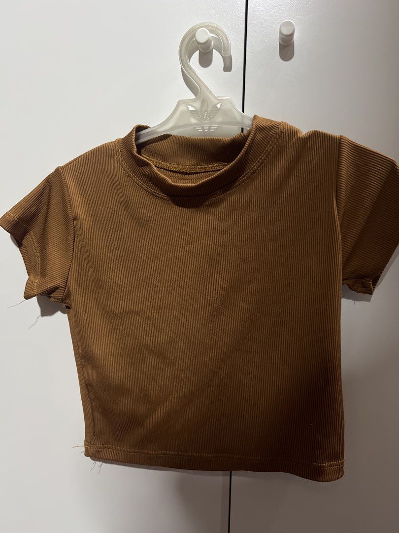 Brown Ribbed Mock Neck Crop Top (Category: Sleeveless) located in Manila. Submitted by twiicee (Listing ID 1461908359, Image 1). Description: - Brown ribbed crop top - Mock neck design - Short sleeves - Raw edge finish on hem and sleeves - Stretchy fabric for comfort - Ideal for casual wear.