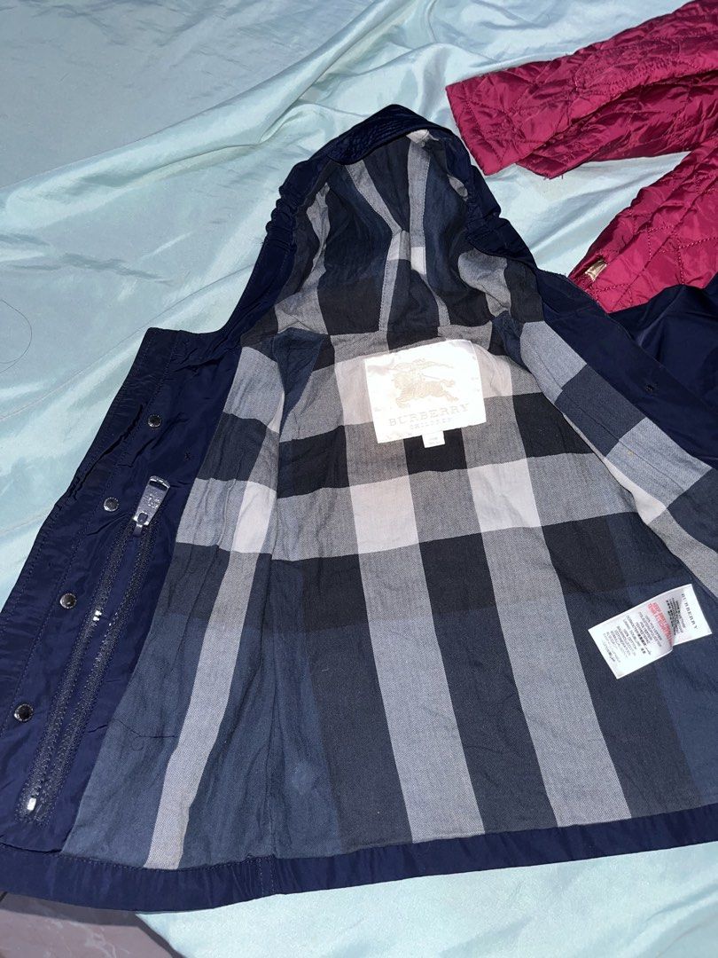 Burberry Children's Navy Blue Hooded Jacket (Category: Babies & Kids Fashion) located in Tabuk. Submitted by collectors_thrift_shop (Listing ID 1461955813, Image 3). Description: - Burberry Children's Jacket - Color: Navy Blue - Size: 24 Months - Iconic Burberry Check Lining - Hooded Design - Zip and Button Closure - Perfect for keeping your child warm and stylish.