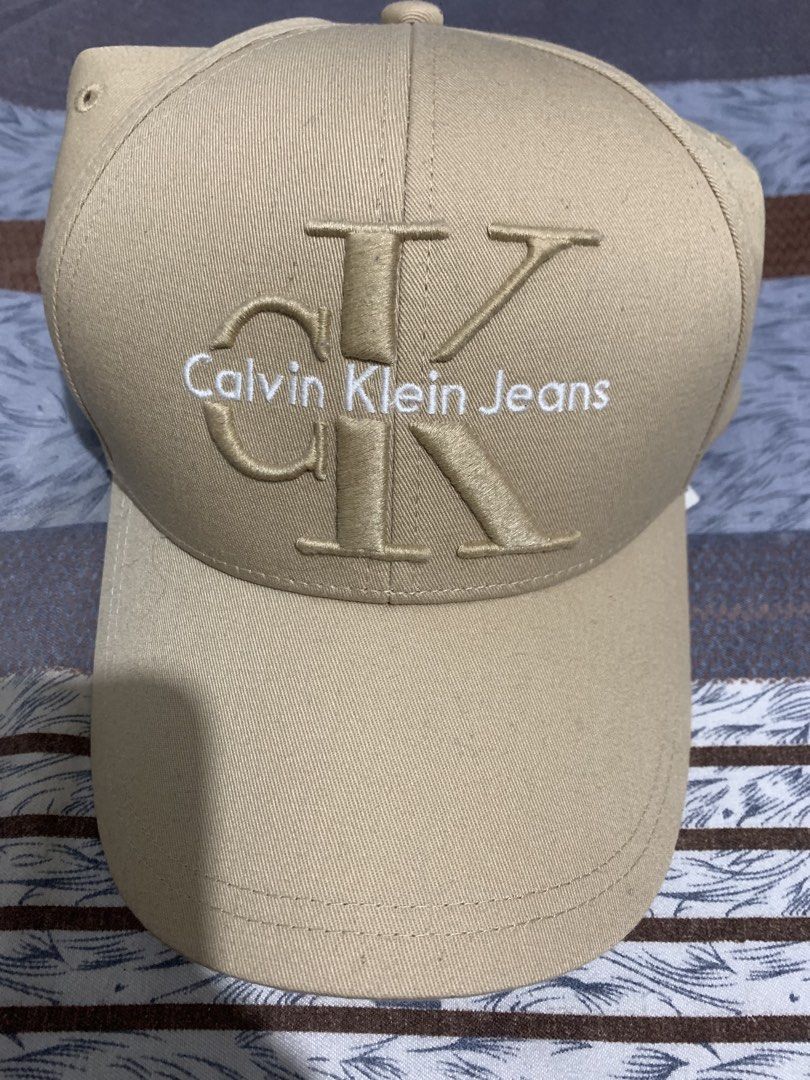 Calvin Klein Jeans Beige Baseball Cap OS (Category: Caps & Hats) located in Pasig City. Submitted by miswatamita (Listing ID 1461845894, Image 1). Description: - Beige Calvin Klein Jeans cap - Features embroidered CK logo on the front.