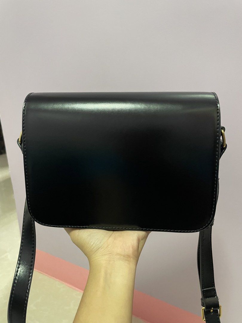 Celine Triomphe Bag Black Leather Gold Hardware (Category: Luxury Bags & Wallets) located in Jaen. Submitted by rocel_abergas (Listing ID 1461875081, Image 2). Description: - Classic black Celine bag - Iconic gold Triomphe clasp - Smooth and shiny leather - Interior zip pocket and main compartment - Adjustable strap for crossbody or shoulder wear - Gold hardware details - Versatile for day or night use.