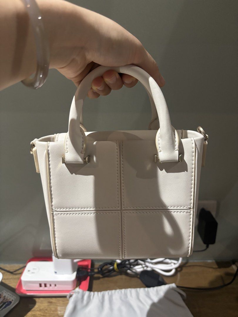Charles & Keith White Top Handle Bag (Category: Luxury Bags & Wallets) located in Paranaque City. Submitted by corinne_see (Listing ID 1461921716, Image 1). Description: - Brand: Charles & Keith - Color: White - Style: Top handle bag - Design: Structured with stitched panel details - Straps: Top handle and detachable shoulder strap - Hardware: Gold accents - Includes: Original dust bag - Versatile: Suitable for daily use or special occasions.