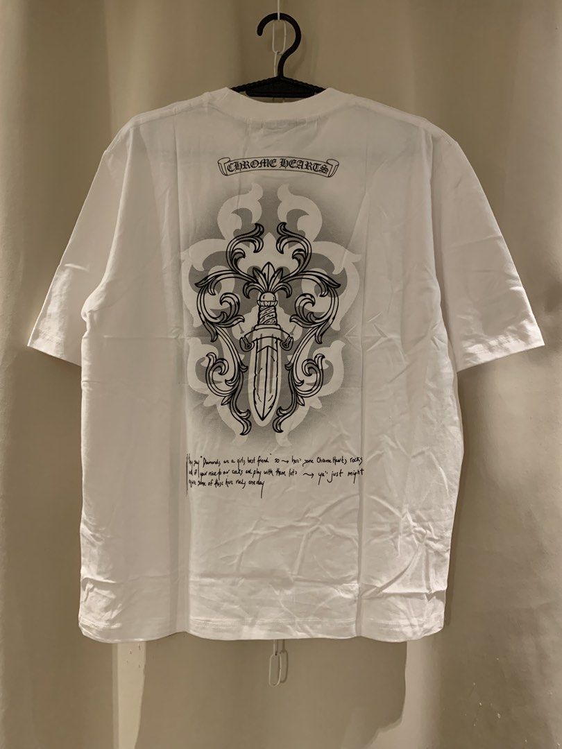 Chrome Hearts White T-Shirt (Category: Tshirts & Polo Shirts ) located in Manila. Submitted by vintaurafindsco. (Listing ID 1461828871, Image 2). Description: - White Chrome Hearts T-shirt - Classic logo on the front - Dagger graphic with text on the back - Tag still attached (brand new) - Perfect addition to any collection.