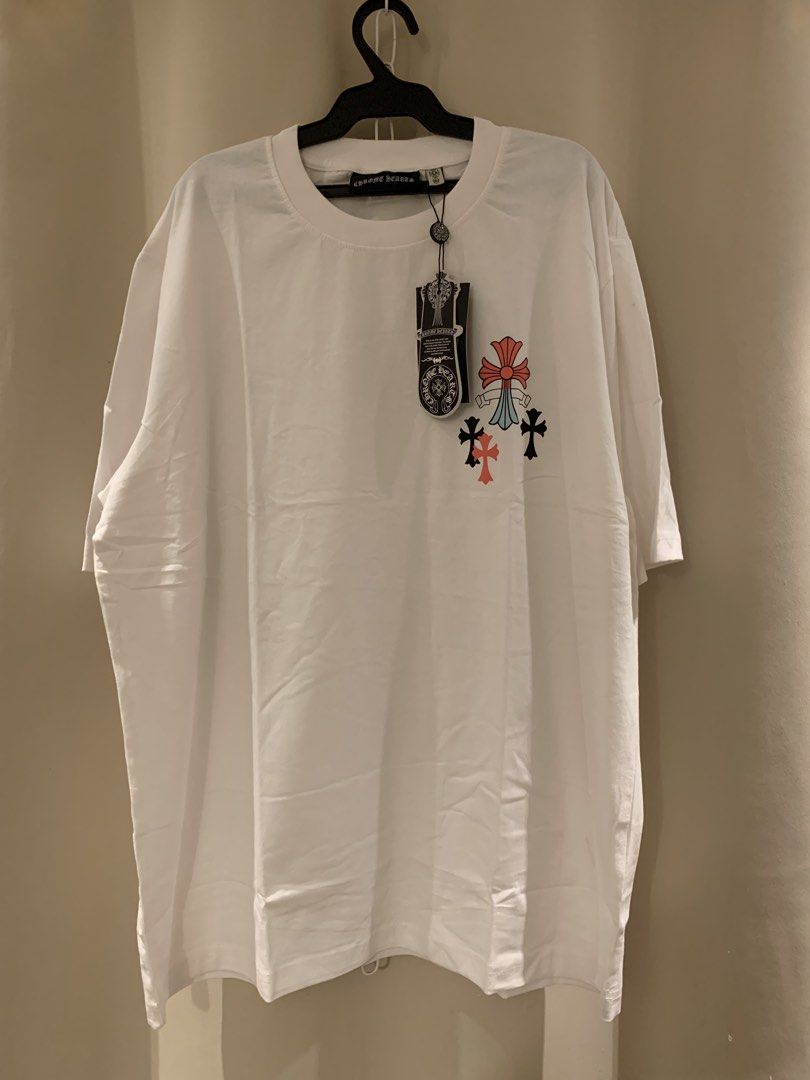 Chrome Hearts White T-Shirt (Category: Tshirts & Polo Shirts ) located in Manila. Submitted by vintaurafindsco. (Listing ID 1461829020, Image 1). Description: - White Chrome Hearts T-shirt - Features iconic cross logo on the front - Large, colorful graphic design on the back - Estimated size: Large or Extra Large (check measurements for exact fit) - Perfect addition to any Chrome Hearts collection.
