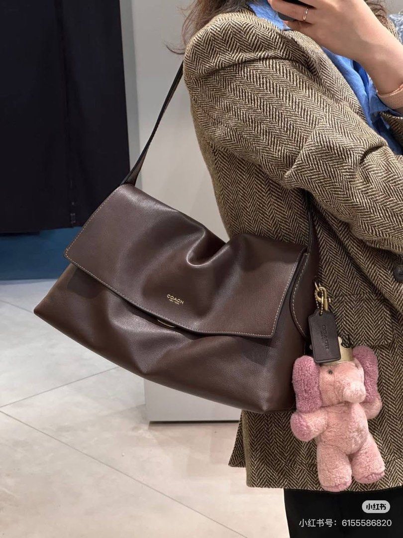 Coach Brown Leather Shoulder Bag with Charm (Category: Luxury Bags & Wallets) located in Quezon City. Submitted by _fculture (Listing ID 1461909267, Image 1). Description: - Coach brown leather shoulder bag - Soft and slouchy design - Comes with a cute pink elephant charm - Ideal for everyday use - Spacious interior - Smooth leather with a beautiful sheen Used twice. Size is 30cm. RFS: sponty buy & need funds Bought it for 2,400.