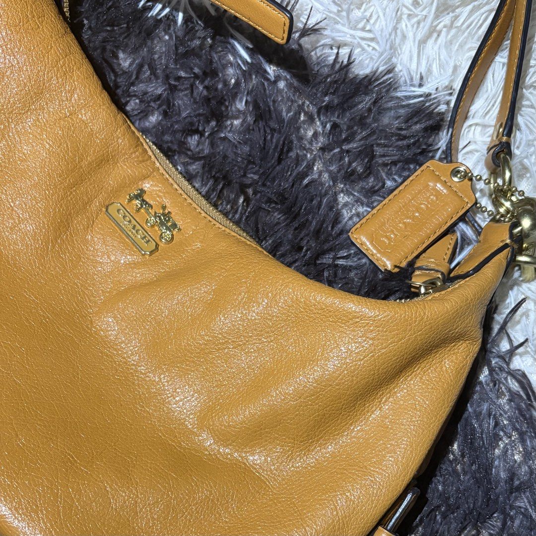 Coach Leather Hobo Shoulder Bag Camel (Category: Luxury Bags & Wallets) located in Makati City. Submitted by chelsitaaaa (Listing ID 1461936657, Image 2). Description: - Coach hobo bag in a versatile camel color. - Made from soft, pebbled genuine leather. - Features elegant gold-tone hardware. - Secure zipper closure. - Interior boasts a vibrant purple lining with a convenient zip pocket. - Comes with the original Coach hangtag. - Adjustable shou