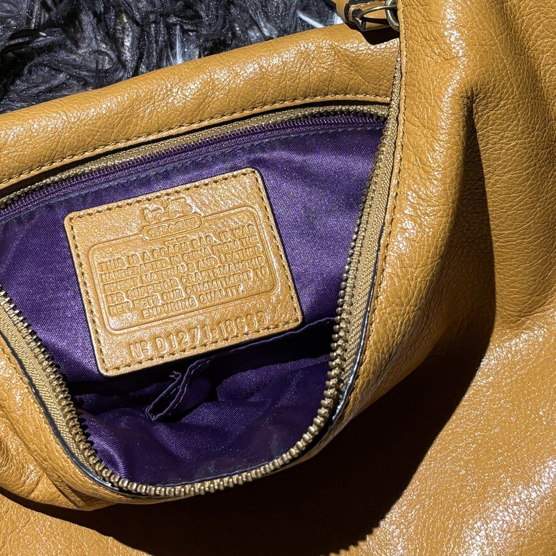 Coach Leather Hobo Shoulder Bag Camel (Category: Luxury Bags & Wallets) located in Makati City. Submitted by chelsitaaaa (Listing ID 1461936657, Image 3). Description: - Coach hobo bag in a versatile camel color. - Made from soft, pebbled genuine leather. - Features elegant gold-tone hardware. - Secure zipper closure. - Interior boasts a vibrant purple lining with a convenient zip pocket. - Comes with the original Coach hangtag. - Adjustable shou