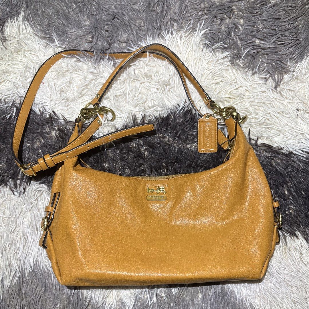 Coach Leather Hobo Shoulder Bag Camel (Category: Luxury Bags & Wallets) located in Makati City. Submitted by chelsitaaaa (Listing ID 1461936657, Image 1). Description: - Coach hobo bag in a versatile camel color. - Made from soft, pebbled genuine leather. - Features elegant gold-tone hardware. - Secure zipper closure. - Interior boasts a vibrant purple lining with a convenient zip pocket. - Comes with the original Coach hangtag. - Adjustable shou