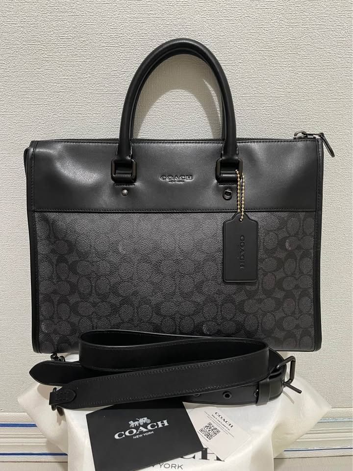 Coach mens bag Gotham Portfolio (Category: Luxury Bags & Wallets) located in Caloocan City. Submitted by benbo18 (Listing ID 1461802674, Image 1). Description: Brand: COACH New York Style: Structured top-handle work/portfolio bag Color: Black with dark charcoal/black Coach Signature pattern Material appearance: Smooth black leather or leather-like upper section with Signature coated canvas on the lower portion. Coach confirms that its Signature c