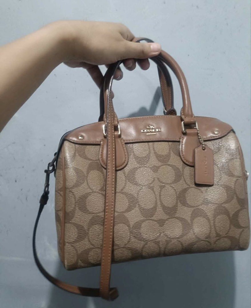 Coach Signature Monogram Satchel Bag (Category: Luxury Bags & Wallets) located in Valenzuela. Submitted by boutiquechic (Listing ID 1461942378, Image 1). Description: - Authentic Coach satchel bag - Signature monogram print in tan and brown - Genuine leather trim and handles - Includes a detachable shoulder strap - Timeless and versatile design - Ideal for everyday wear.
