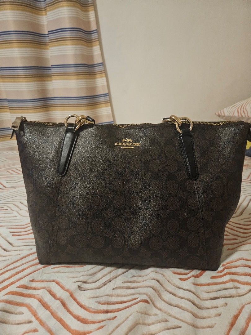 Coach Signature Monogram Tote Bag (Category: Luxury Bags & Wallets) located in Manila. Submitted by gcprime (Listing ID 1461834163, Image 1). Description: - Classic Coach tote bag - Color: Dark brown - Signature C monogram pattern - Gold hardware details - Zipper closure - Comfortable handle length - Spacious interior - Ideal for everyday use - with few chips that could be seen in the photos - Price listed is slightly negotiable.