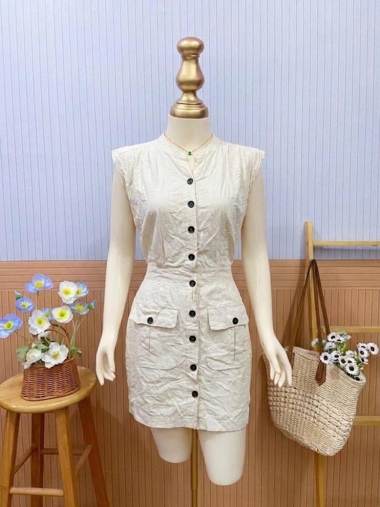 Cream Button-Down Dress (Category: Dresses) located in Roxas City. Submitted by blairnstyle (Listing ID 1462028826, Image 1). Description: Base Fabric & Color: light cream linen-blend cotton. ​Neckline & Sleeves: Collarless round V-neckline with structured, capless padded shoulder sleeves ​Front Closure: Full-length front placket with dark contrast buttons running top-to-bottom ​Pocket Details: Dual flap utility pockets at the front hips featurin