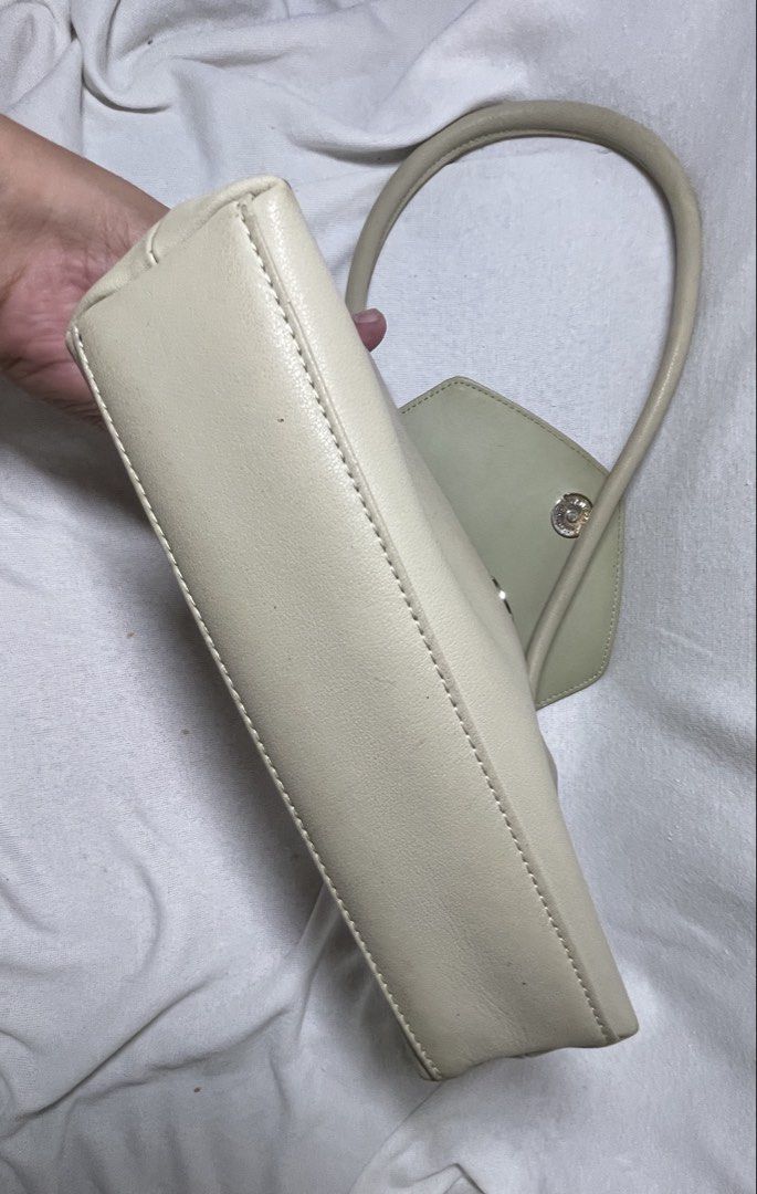 Cream Envelope Shoulder Bag with Gold Clasp (Category: Luxury Bags & Wallets) located in Mandaluyong City. Submitted by coolmeybab (Listing ID 1461822383, Image 3). Description: - Elegant cream-colored shoulder bag - Stylish envelope flap with a secure gold clasp closure - Comfortable single curved handle - Interior includes a zippered pocket and a small slip pocket for organization - Clean and well-maintained lining.